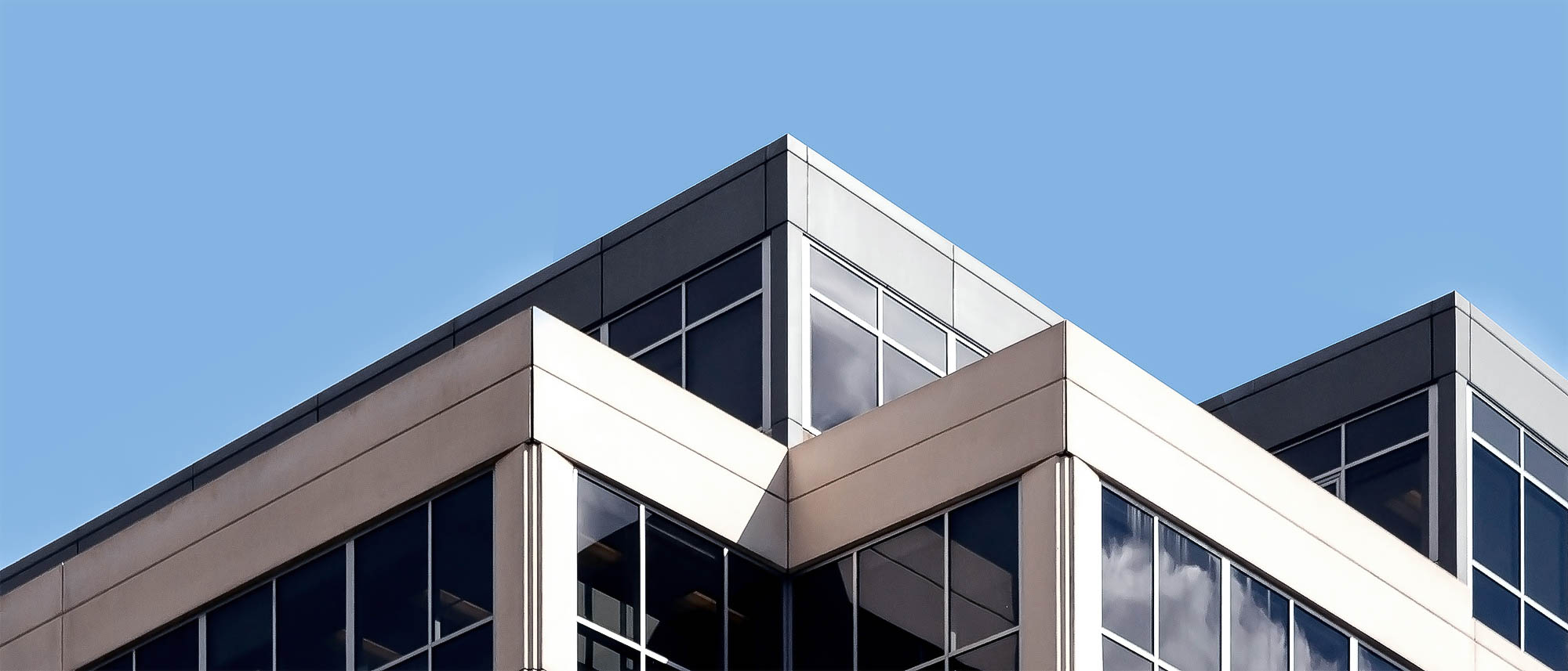 graues gebäude mit folierten scheiben als beispielbild für folien und vliesstoffe von dunmore für die bauindustrie