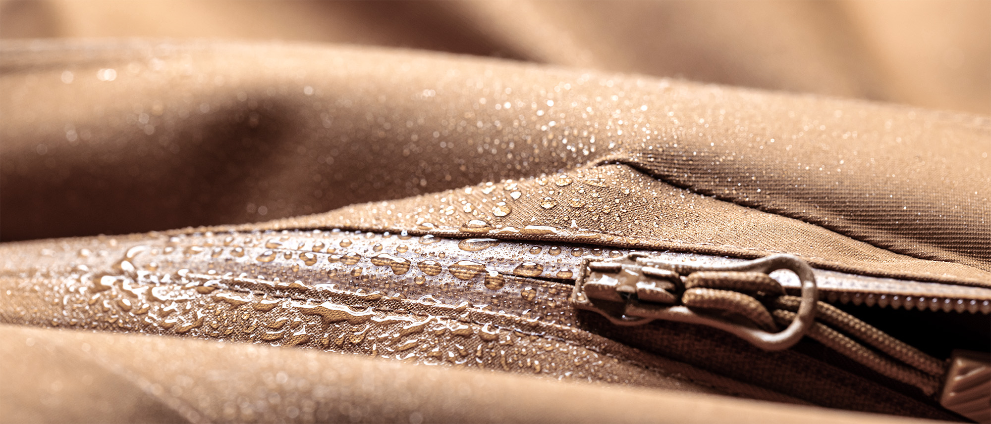 nahaufnahme wasser perlt auf braunem stoff ab beispiel für textil beschichtung von dunmore europe